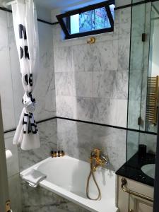 佛罗伦萨Suite Presto的带浴缸、水槽和窗户的浴室