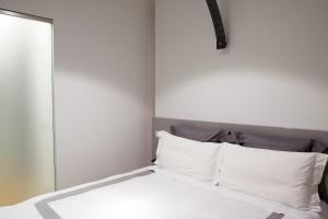 米兰Milano Repubblica Suite Centro的一张带白色床单和枕头的床