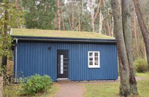 青斯特chalet Zingst的蓝色的棚子,有草屋顶和门