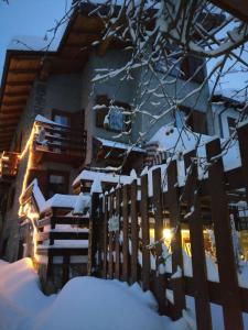 奥斯塔欧洲滑雪住宿加早餐旅馆的房屋前有雪覆盖的栅栏