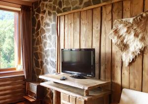 Kraevo马克别墅酒店的坐在木桌旁的电视机