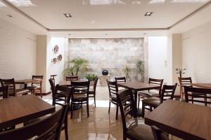 ZitácuaroHotel Maria Fernanda Inn的餐厅设有木桌和椅子,拥有砖墙
