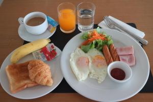 莱卡邦L42素万那普机场旅馆的餐桌,包括两盘早餐食品和一杯咖啡