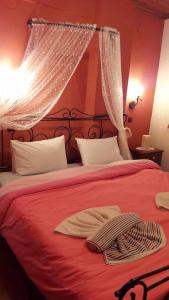 Palaioi PoroiIppoliti的一间卧室配有红色的床和红色毯子