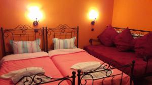 Palaioi PoroiIppoliti的卧室内的两张床,配有红色床单和枕头