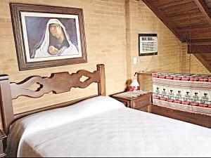 乌巴图巴Recanto Marazul的卧室配有一张床,并画着修女