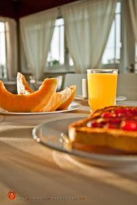 皮里亚波利斯Hotel Esmeralda的桌子上放两盘橘子和一杯橙汁