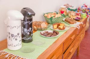 蒂拉登特斯Pouso copo de leite的一张木桌,上面有面包和糕点