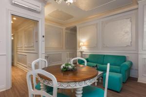维罗纳Guelphs Apartments的客厅配有桌子和绿色沙发