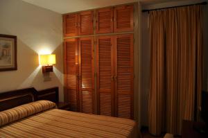 帕洛斯德拉夫龙特拉圣玛丽亚酒店的一间卧室配有一张床、一个衣柜和一盏灯。