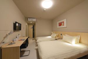 苏州锦江之星苏州火车站北广场酒店的一间医院间,配有两张床和一张书桌