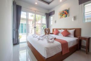拉威海滩顺度假村的一间卧室设有一张大床和大窗户