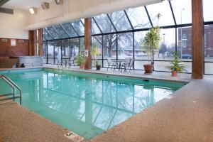 HuronCrossroads Hotel and Huron Event Center的一座大型游泳池,位于一座带玻璃窗的建筑内