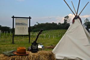 穆克莱克查尔伊萨拉酒庄度假村的田野上带标志的帽子和帐篷