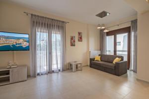 GállosAll Seasons Villas的带沙发和平面电视的客厅