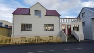 侯尔马维克Steinhúsið的白色的房子,有红色的门和黄色的栅栏