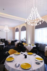 Chazelles-sur-Lyon布兰查德城堡酒店的餐厅设有白色的桌子、黄色的椅子和吊灯