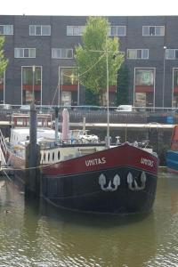 鹿特丹B&B Unitas的船停靠在建筑物旁边的水中