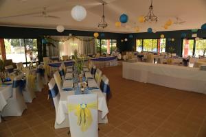 Coochiemudlo靴子岛塞米纳拉公寓式酒店的宴会厅配有白色桌子以及蓝色和黄色的椅子