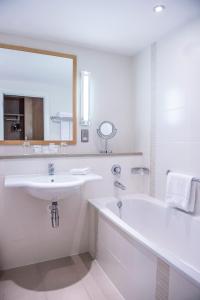 科克瑞维尔李酒店 - 多伊尔酒店集团的一间带水槽、浴缸和镜子的浴室
