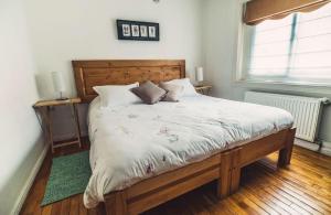 蓬塔阿雷纳斯Innata Casa Hostal的一间卧室配有一张大床和木制床头板