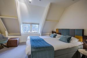 海伦多伦Landgoed De Uitkijk Hellendoorn的一间卧室设有一张大床和大窗户