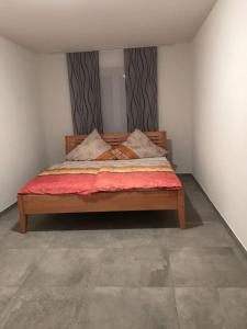 腓特烈港Casa Friedolin的卧室配有一张大床,提供红色床单和枕头