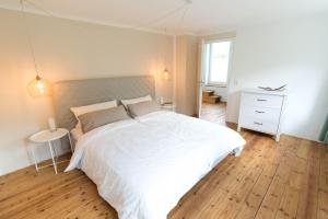 吕贝克Refugium-Luebeck的卧室设有一张白色大床和木地板