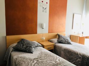 特鲁埃尔维纳斯17酒店的一间卧室配有两张床,中间设有床头柜。