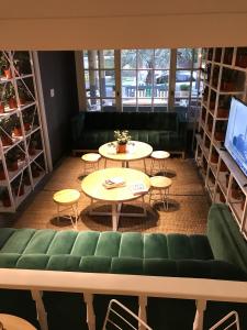 埃斯特角城Hotel Dollar的一间设有两张桌子和一张绿色沙发的房间