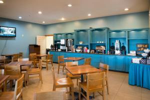 埃芬汉埃芬汉乡村套房酒店的餐厅设有蓝色橱柜和木桌及椅子