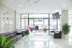 胡志明市索莱克斯酒店的大堂配有沙发、电视和鲜花