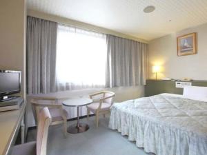 京都京都帕尔赛斯旅馆的酒店客房带一张床、一张桌子和椅子