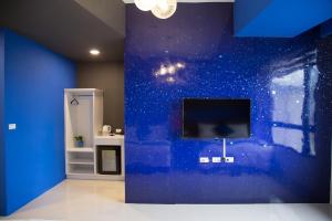吉安BUDDY 35的一间设有蓝色墙壁和平面电视的客房
