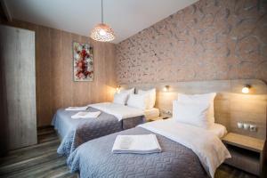 博尔若米Milano Palace Borjomi的酒店客房,配有两张带白色床单的床