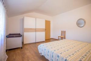 RadovaniApartment Sterna的一间卧室配有一张床、一个橱柜和一把椅子