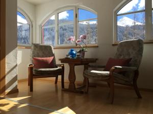 FrauenkirchBnB Guesthouse Lusi的带窗户的客房内配有两把椅子和一张桌子
