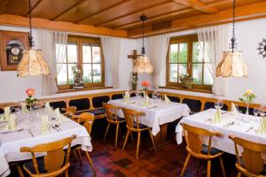 阿尔腾斯塔特祖姆鲁斯勒酒店的一间设有白色桌椅和窗户的用餐室