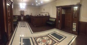 圣彼得堡卡梅尔蒂奈酒店的一间铺有瓷砖地板的客厅和一间带桌子的房间