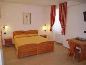福尔加里亚Hotel Seggiovia的一间卧室配有一张床、一张桌子和一张书桌