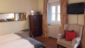 慕尼黑王子旅馆的一间卧室配有一张床、一把椅子和镜子