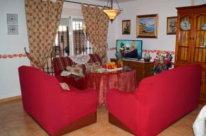 贝瑙汉卡萨伊莎贝尔度假屋的客厅配有2把红色椅子和桌子