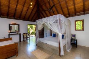 坦加拉Palm Paradise Cabanas & Villas Beach Resort的一间卧室配有一张带天蓬的床