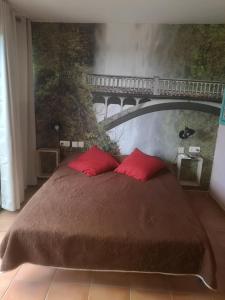 埃拉特Casa Rosa的一间卧室配有一张带红色枕头的床和一座桥
