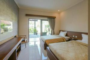 库塔阿尔纳亚民宿的酒店客房设有两张床和一个阳台。