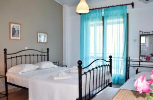 拉扎克利翁奥斯特里亚之家公寓的一间卧室设有两张床,窗户配有蓝色窗帘
