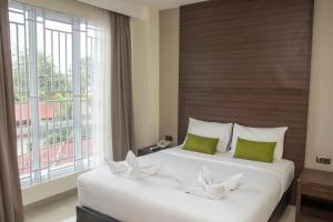 美娜多绿色伊甸园酒店的一间卧室设有两张床和大窗户