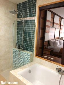 彭世洛塔曼度假酒店的带浴缸和镜子的浴室