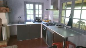 QuinsacLe Gîte的厨房配有水槽和炉灶 顶部烤箱