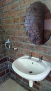 莫希Kitolie Home and Lodge的浴室设有水槽和砖墙上的镜子